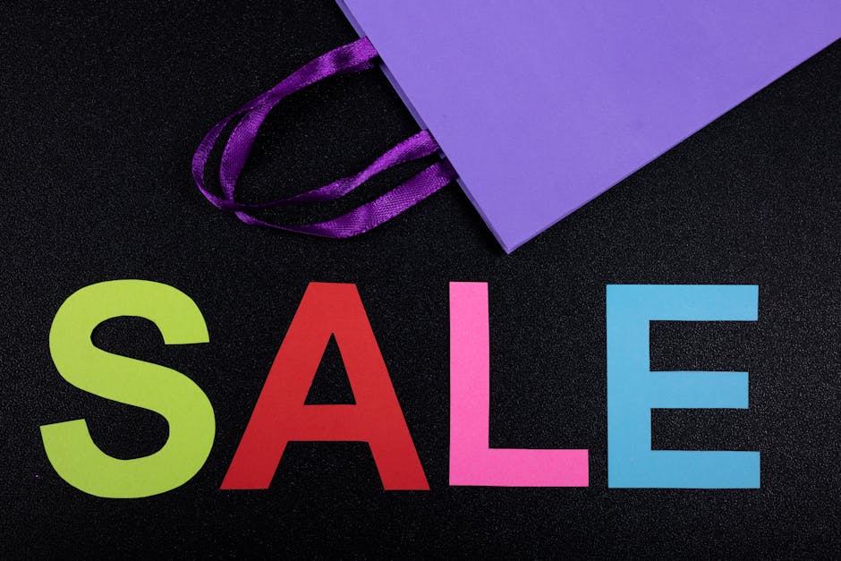 Brightly colored letters spelling sale with a purple paper bag on black background.