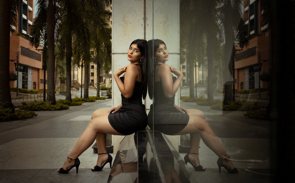 A stylish woman in a black dress poses with her reflection in Bucaramanga, Colombia.
